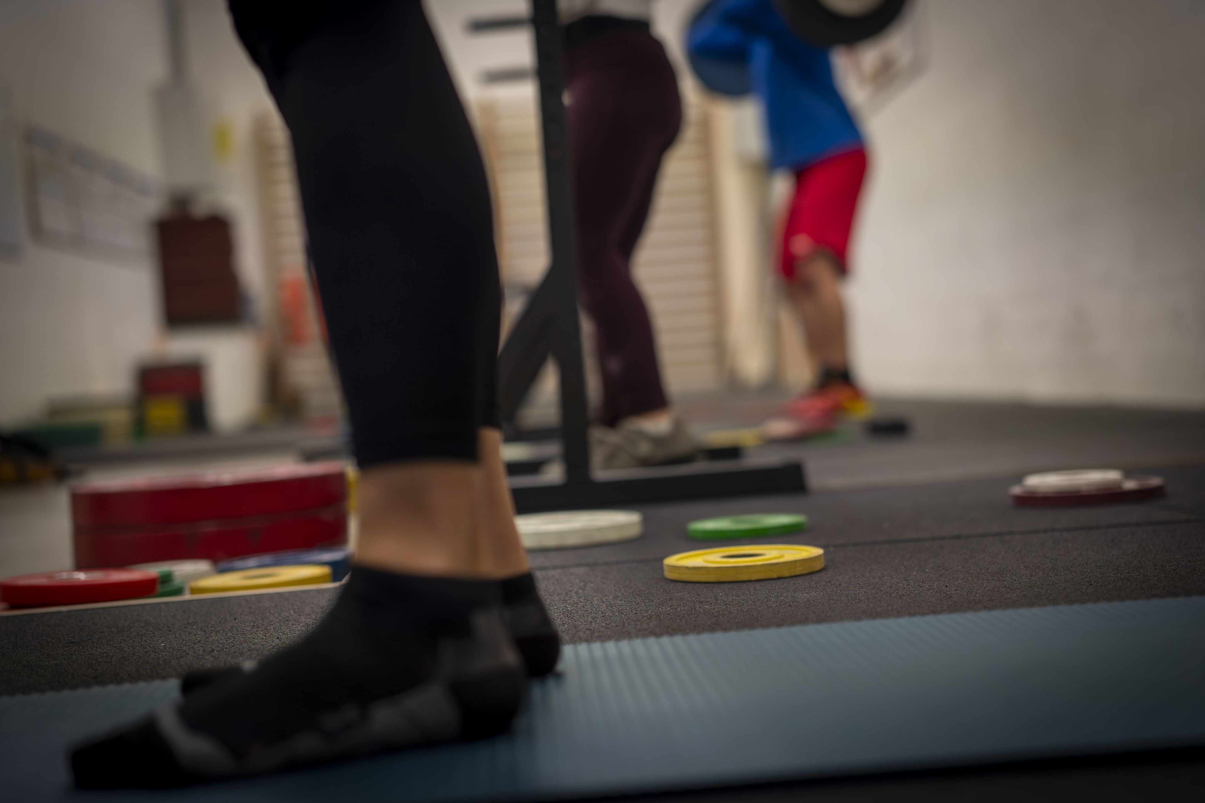 Die Füsse von drei trainierenden Gewichtheber*innen sind zu sehen