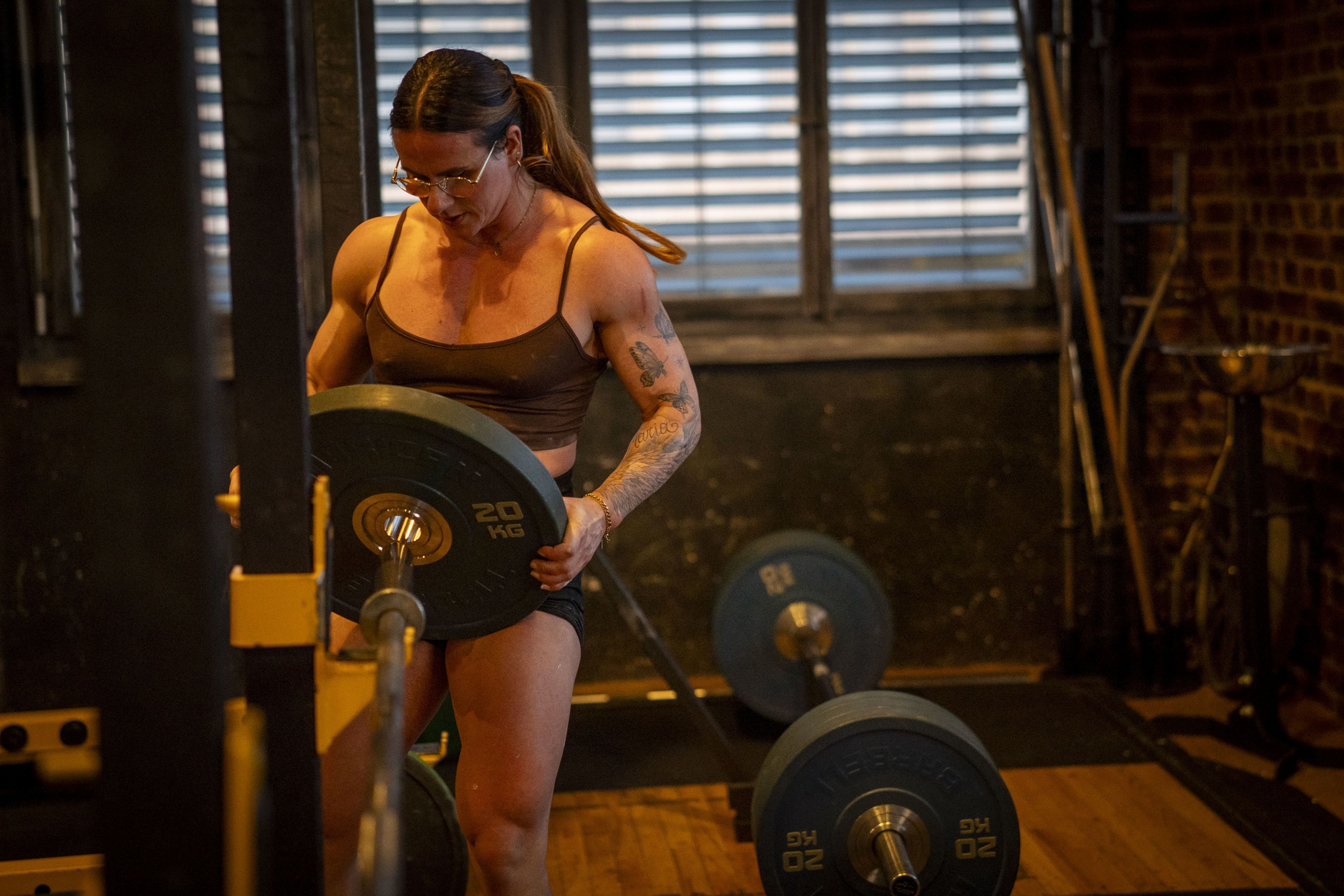 Frau schiebt Gewicht auf eine Langhantel