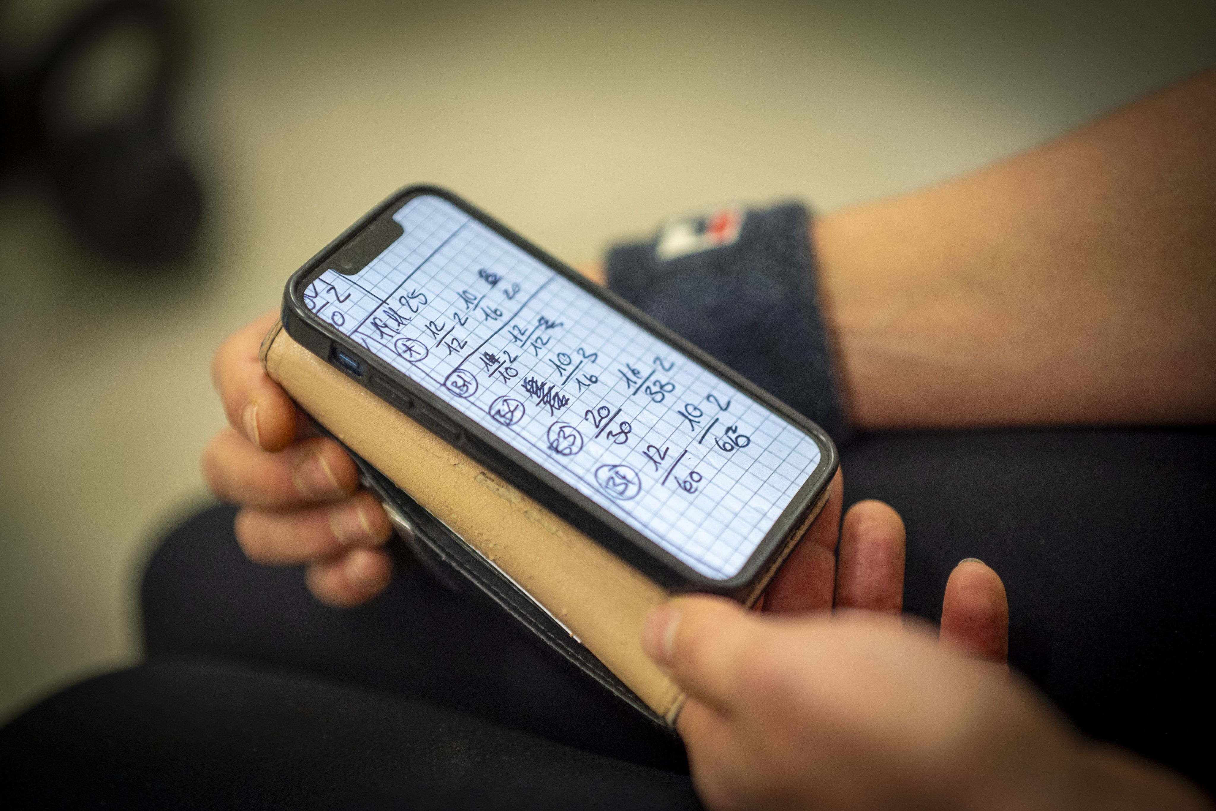 Handy, das einen handschriftlichen Trainingsplan zeigt.