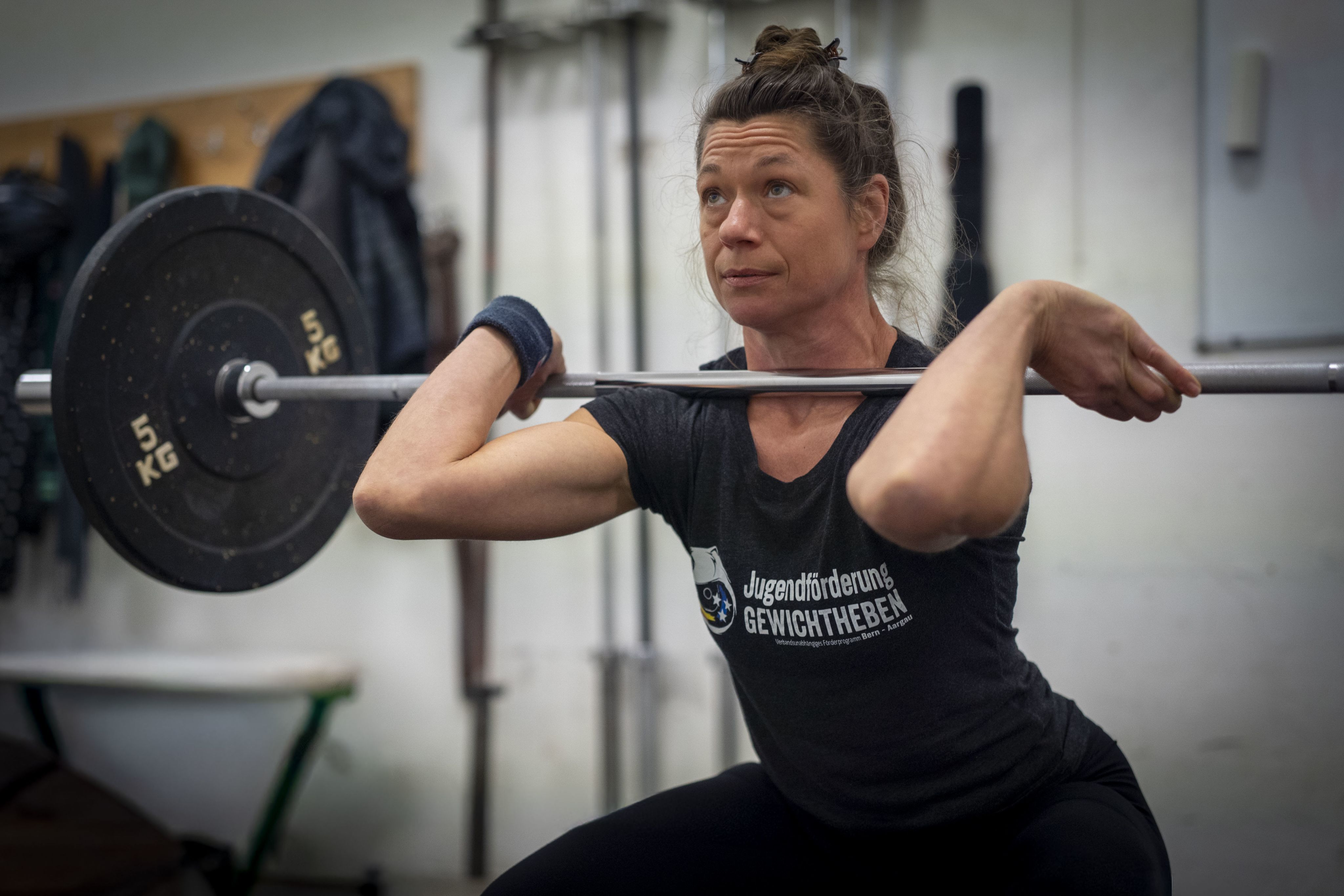 Die Gewichtheberin squatet mit einer Langhantel