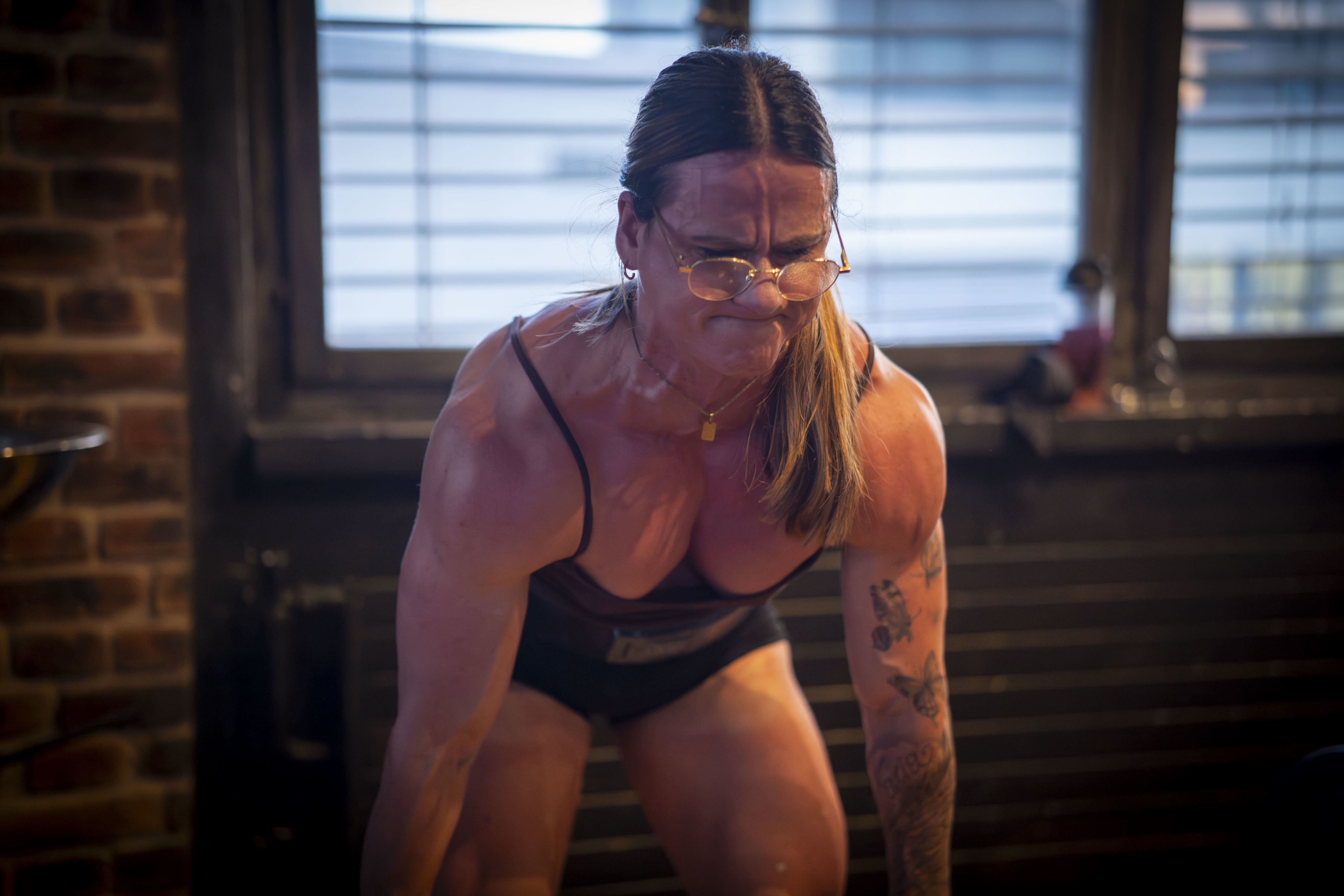 Frau hebt eine schwere Langhantel unter grosser Anstrengung